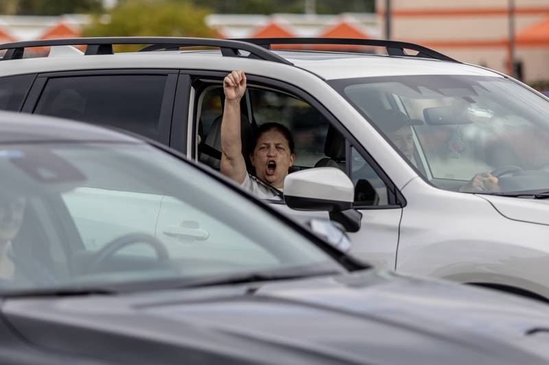 A passenger raises a fist in solidarity with protestors during the No Kings Protest at Mall Loop Drive in Joliet on Oct. 18, 2025.