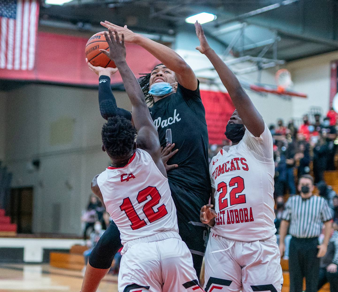 Oswego East's Patrick Robinson (1) shoots the ball in the post against East Aurora's Ralph Clark (12) and Stephen Dorsey (22) during the 11th Annual Kivisto Hoopfest at East Aurora on Saturday, Feb 5, 2022.