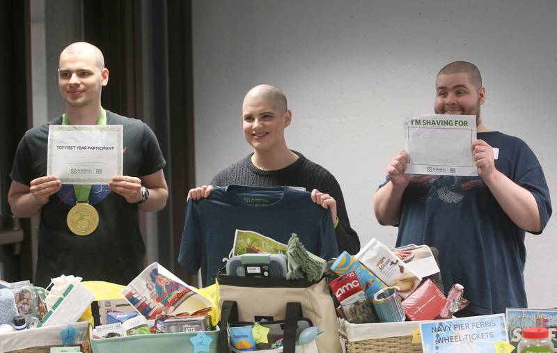 Shavees (from left) Aaron Noble, Avriel Miers and Daniel Taglia pose for a photo by the raffle table during the first ever St. Baldrick's event on Wednesday, April 30, 2025 at Illinois Valley Community College.