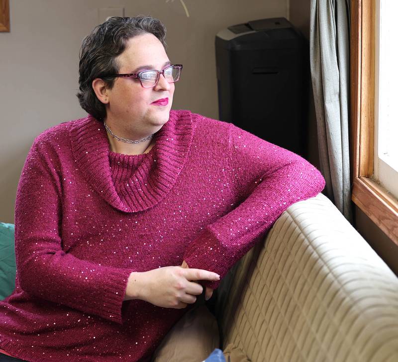 Elizabeth Fern Jensen looks out a window in the home she shares with fiancé Jamie Jensen Tuesday, Dec. 13, 2022, in DeKalb.