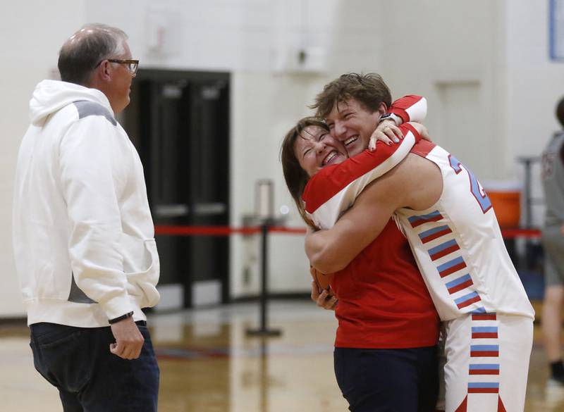 Marian Central’s Christian Bentancur hugs his mother, Elizabeth, after scoring his 2,000 point, as his father, Patrick, watches during a nononference boys basketball game against Marengo on Tuesday, Feb.13, 2024, at Marian Central High School.