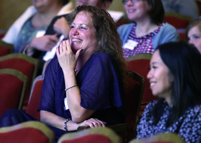 Athena Award recipient Jennifer Yochem laughs as she listens to her presenter Christine Kalina talk about her Thursday, Oct. 10, 2024, during the Athena and Women of Accomplishment Awards reception hosted by the DeKalb Chamber of Commerce at the Egyptian Theatre.
