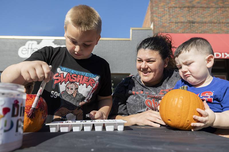 Delsin (left), 8, and Oriax Mulnix, 2, work on crafting a work of art pumpkin with mom Candice Johnson Saturday, Oct. 22, 2022 during Dixon’s Scarecrow Fest.
