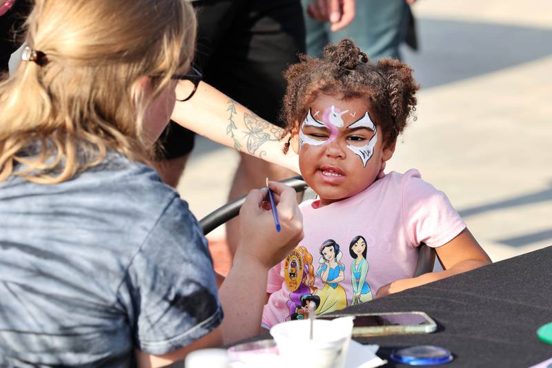Amari’Lee Rogers, 3, from DeKalb, isn’t sure about the face painting during National Night Out Tuesday, Aug. 1, 2023, in the Hy-Vee parking lot in Sycamore.