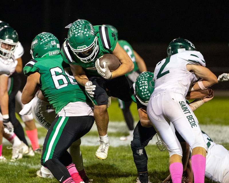 Cam Sriey (33) of Seneca jumps between his defense whilst running ball on Friday, Oct. 10, 2025 at Seneca High School in Seneca.