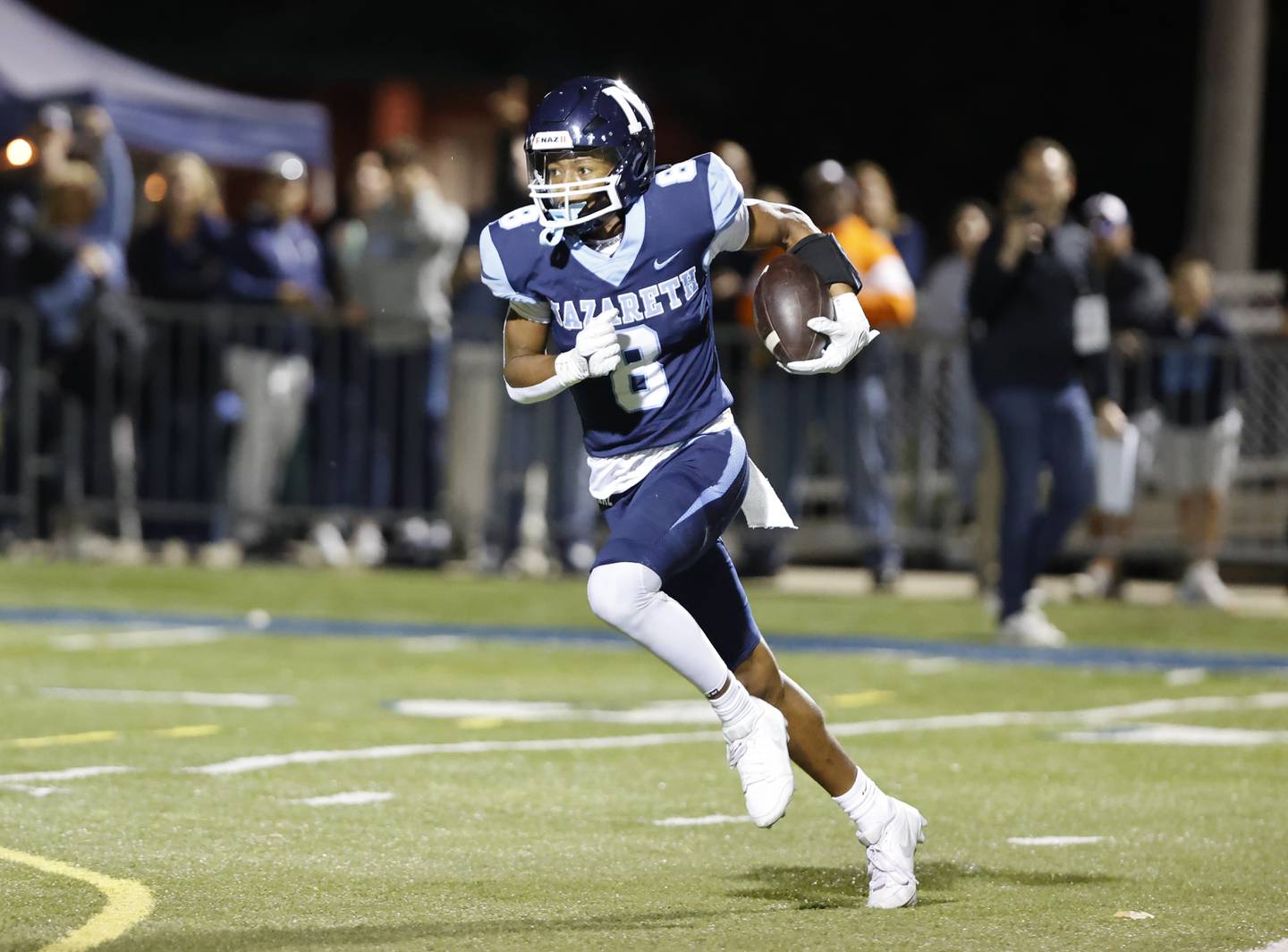 Nazareth's Trenton Walker (8) runs with the ball during the varsity football game between Joliet Catholic and Nazareth academies on Friday, Sep. 27, 2024 in La Grange Park.