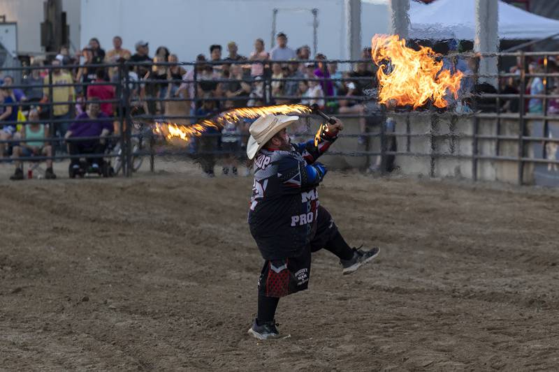 Rodeo entertainer Pork Chop handles a flaming whip Tuesday, August 15, 2023 in the Next Level Pro Bull Riding event at the Whiteside County Fair.