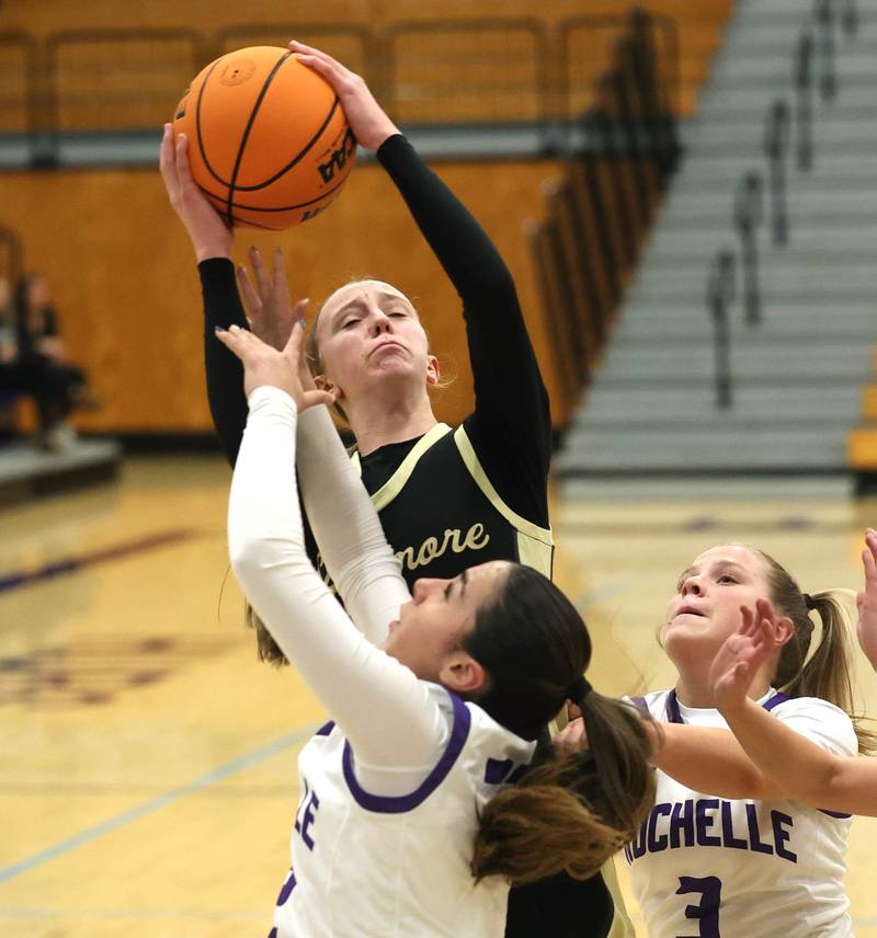 Sycamore's Sadie Lang grabs a rebound over Rochelle’s Gianna Olguin Friday, Dec. 5, 2025, during their game at Rochelle High School.