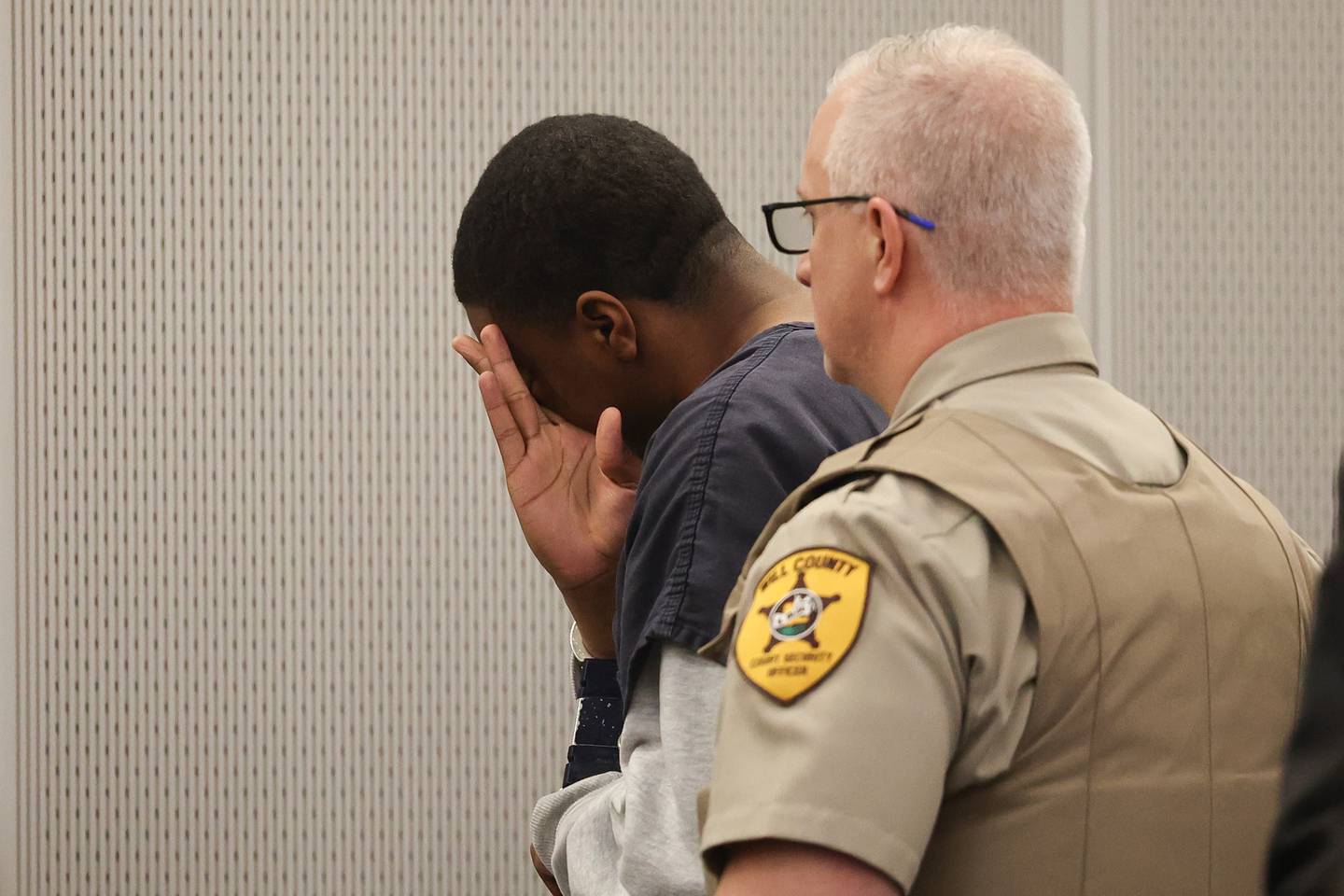 Byrion Montgomery, 17, of Bolingbrook, hides his emotional break down as he leaves his hearing at the Will County Courthouse on Thursday, March 30, 2023 in Joliet. Montgomery is accused of the murders of Cartez Daniels, 40, Samiya Shelton-Tillman, 17, and Sanai Daniels, 9, at a residence in the 100 block of Lee Lane in Bolingbrook, as well as attempted first-degree murder of Tania Stewart.