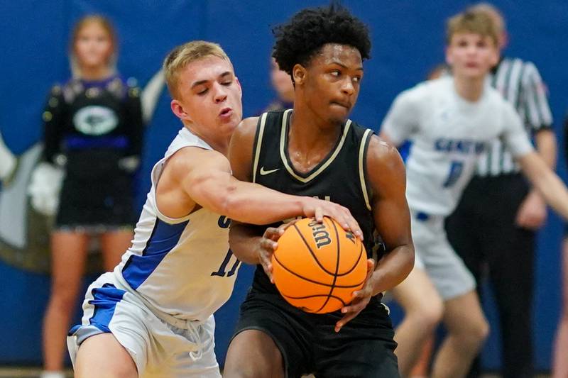 Geneva’s Nelson J Wendell (11) attempts a steal against Glenbard North's Maharri Thatch (21) during a class 4A Geneva Regional final basketball game at Geneva High School on Friday, Feb. 28, 2025.