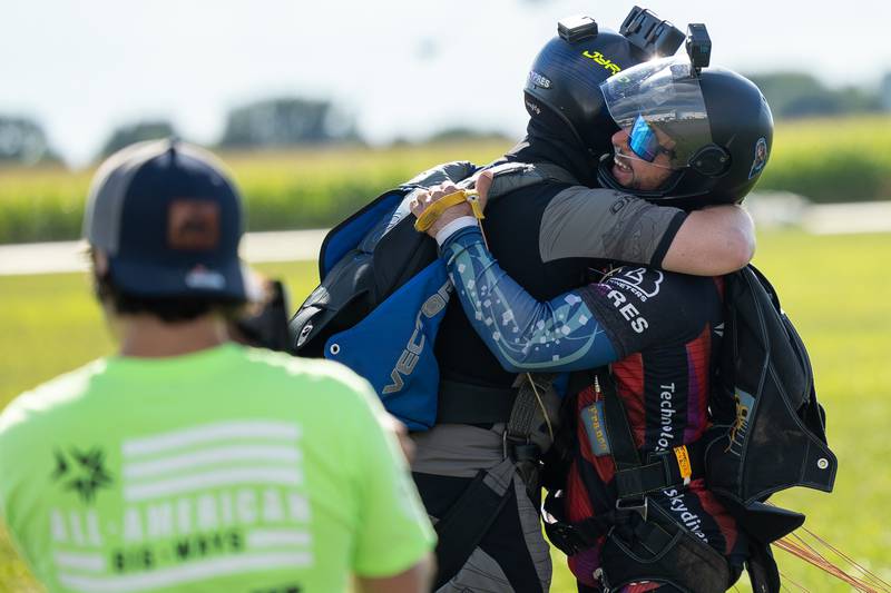 (from left) Matias Parker hugs Franco Darman in drop zone after jump on Friday, Aug 22, 2025 above Skydive Chicago in Ottawa.