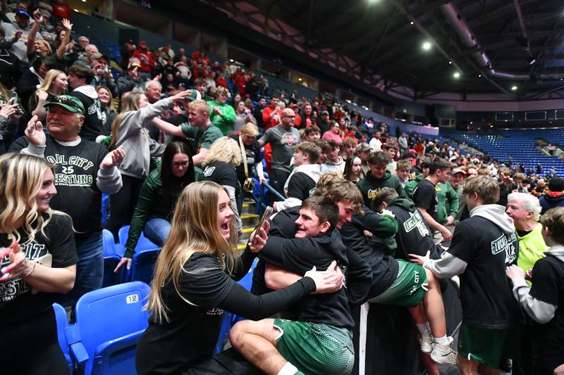 Coal City wrestlers climb into the stands to celebrate their Class 1A first place finish during the IHSA Dual Team State Finals in Bloomington on Saturday, March 1.