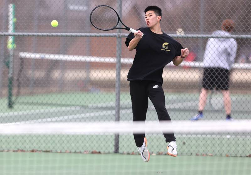 Sycamore’s number one singles player Steven Chen jumps as he hits a forehand during his match against Dixon Thursday, March 30, 2023, at Sycamore High School. This is the inaugural season for the Sycamore boys tennis team.