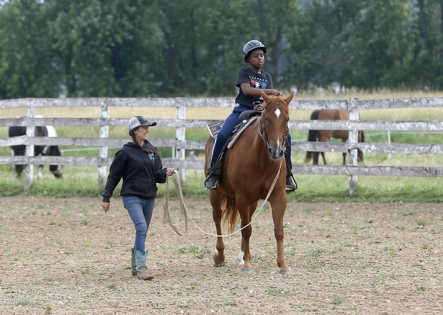 Barn manager Melissa Capra gives Richard Taylor-Terry, 11, a riding lesson on retired Medieval Times horse, Hunter, Friday July, 8, 2022, at the R Double J Ranch, 2800 Derby Lane, in McHenry. The R Double J Ranch recently got the contract to operate this equine facility from McHenry with the goal of making it more of a community-centric center and make learning about horses and riding open to all.