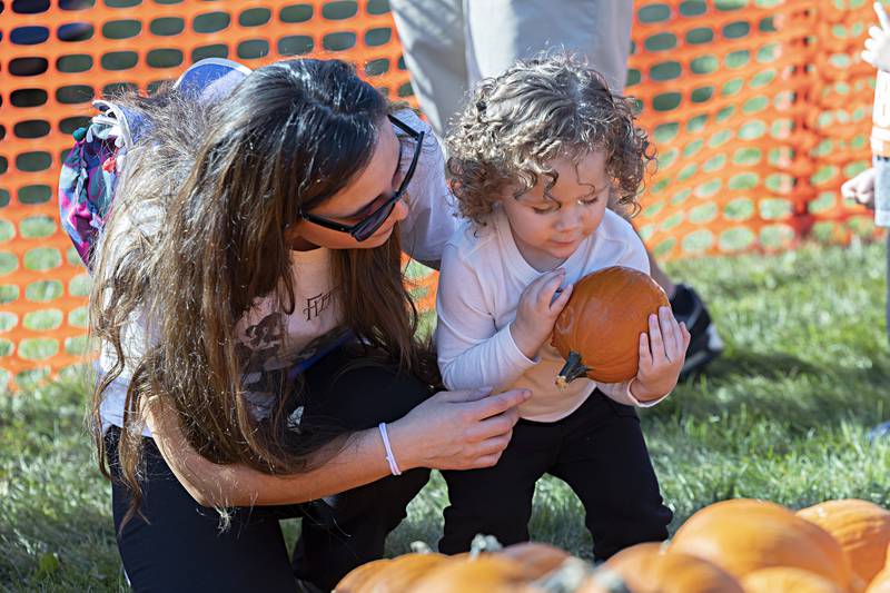 Luna Grace, 2, and Nancy Uresti choose a pumpkin Saturday, Sept. 30, 2023 after the young one completed her Pumpkin Dash race.