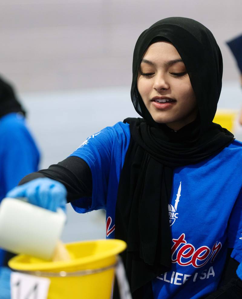 Nabiha Siddiqui of Glendale Heights adds an ingredient to a food package during the Islamic Relief USA meal packing event at College Preparatory School of America on Saturday, March 9, 2024 in Lombard.