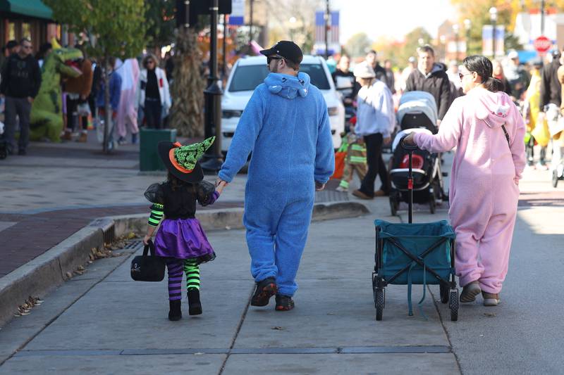 A family walks along West Lockport Street at the annual Halloween Spooktacular in downtown Plainfield on Saturday, Oct. 28, 2023.