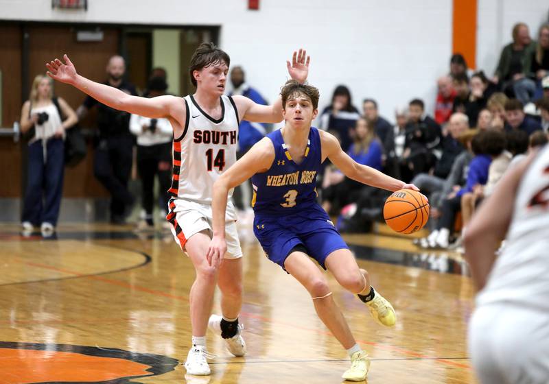 Wheaton North’s Cal MacKay drives toward the basket past Wheaton Warrenville South's Sean Doherty during a game  on Friday, Feb. 7, 2025 in Wheaton.