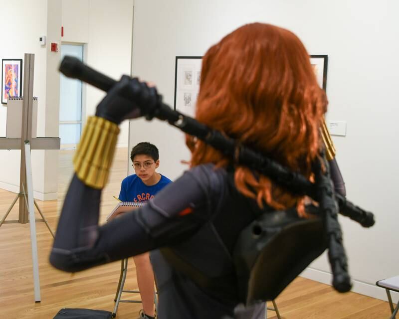 Sam Apolinar, 13 years old, of Lombard draws Lisa J. who portrays Black Widow during a live model demonstration on Saturday June 24, 2023 during The Marvelcity: The Art of Alex Ross exhibit held at the Elmhurst Museum.