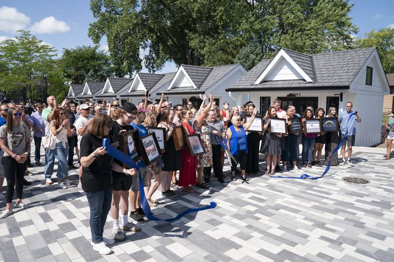 Shop owners and local officials officially open the new McHenry Riverwalk Shoppes in downtown McHenry with a ribbon cutting ceremony on Friday, July 21, 2023.