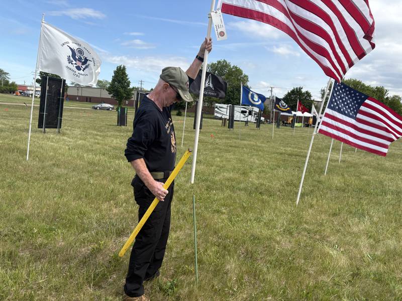 Bill Lunsford adjusts a flag at the Field of the Fallen in Cary May 23, 2026.