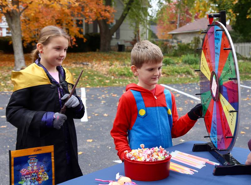 Sydney and Luke Krall take turns spinning a prize wheel at the 9th Annual Trunk or Treat at the Elburn Community Congregational Church on Sunday, Oct. 29, 2023 in Elburn.