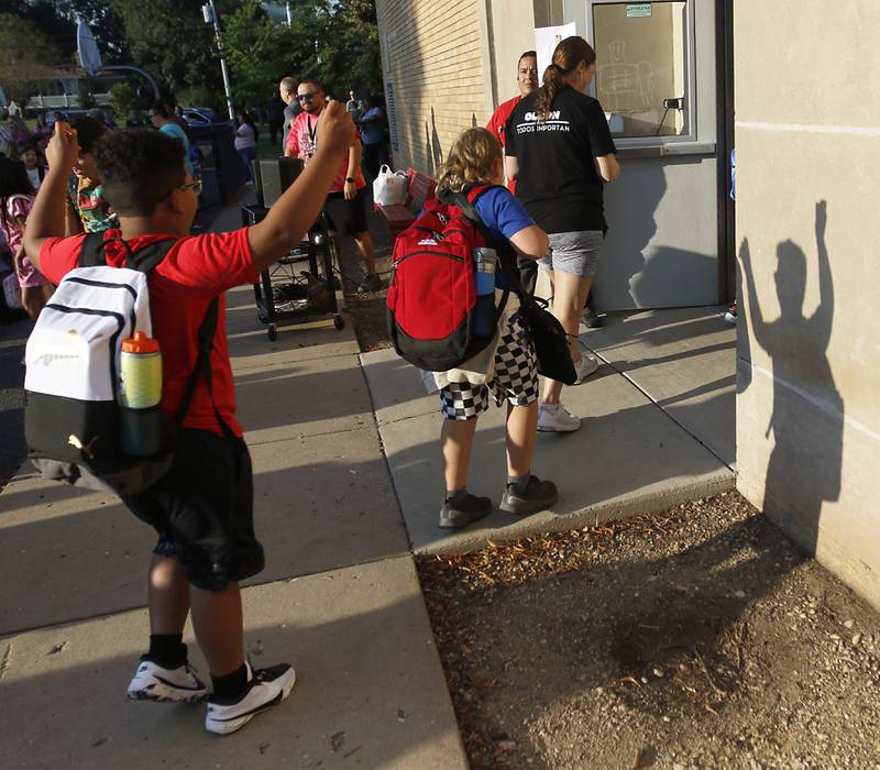 A student celebrates the first day of school as he was into the school into Olson Elementary School in Woodstock, on Wednesday, Aug. 14, 2024.