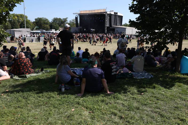 Festival goers find shade during the The Juliana Theory performance at the Radicals stage on day three of Riot Fest. Saturday, Sept. 18, 2022, in Chicago.