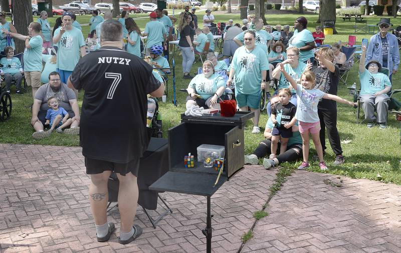Looking for a volunteer from the audience, Mark Nutzy Padgett, a local magician, performs his act Tuesday, Aug. 8, 2023, during Unlimited Fun Day at City Park in Streator. The event was sponsored by Streator Unlimited.