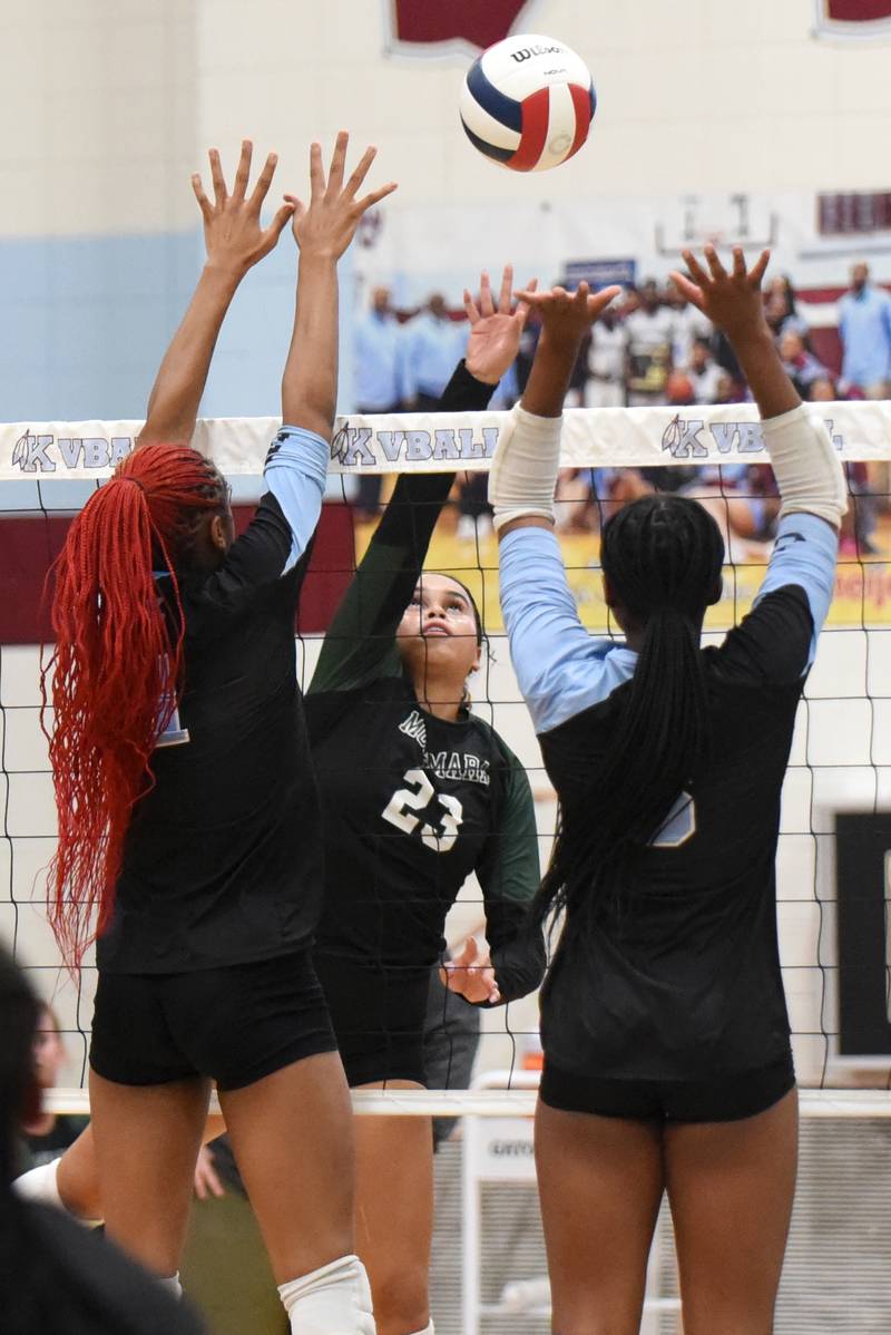 Bishop McNamara's Journey Slone, center, looks to place a hit between Kankakee's Ki'Asia Wilson, left, and Erin Wills during an All-City game at Kankakee Wednesday, Sept. 3, 2025.