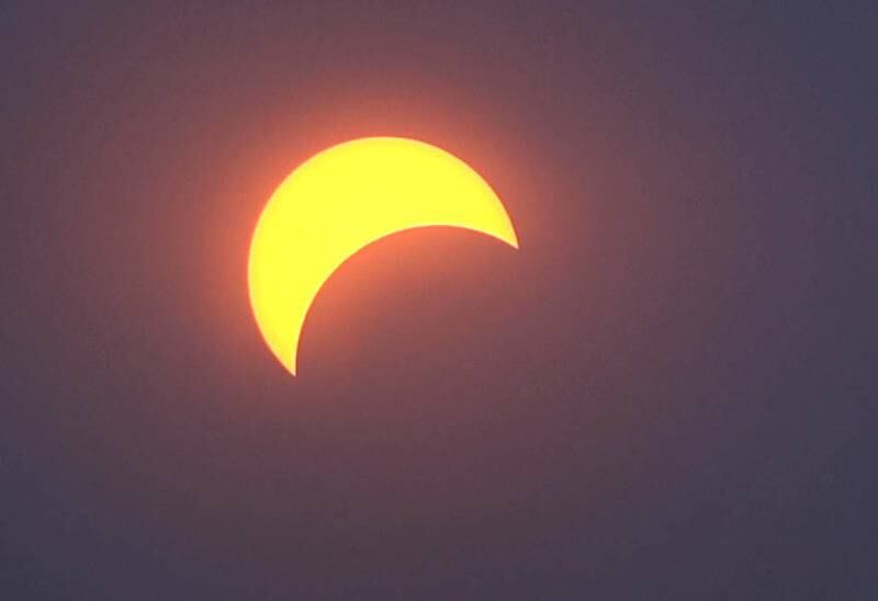 The moon covers about half of the sun during the eclipse Monday, April 8, 2024, as seen from the Northern Illinois University Solar Eclipse Viewing Party behind Davis Hall in DeKalb. Attendees were treated to perfect weather to watch the rare celestial event.