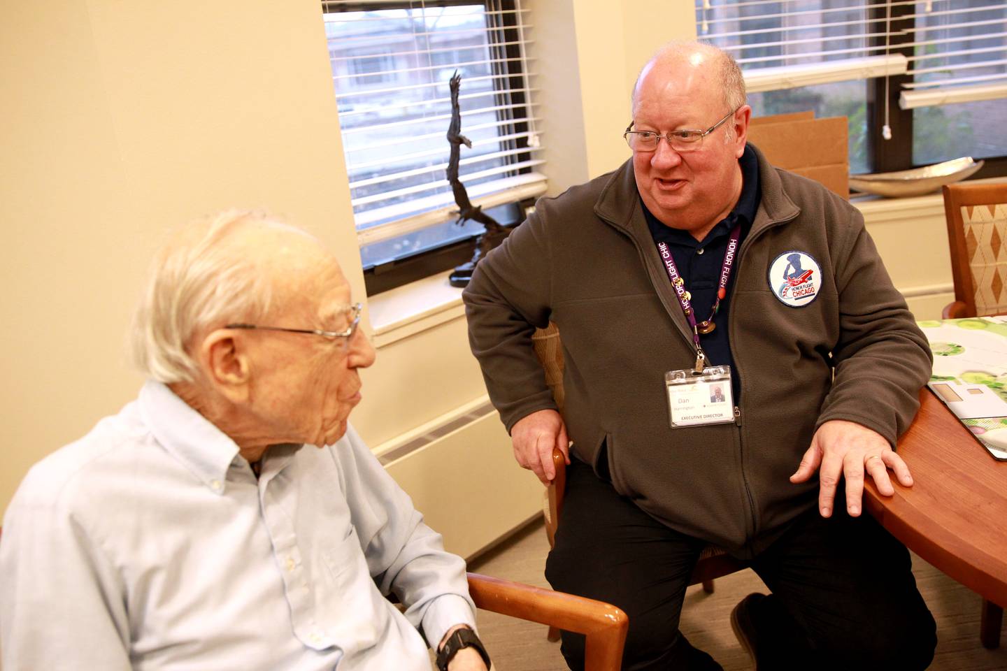 Dan Harrington, executive director of Oak Trace senior living in Downers Grove, talks with resident Jim Leichti, a World War II veteran. Harrington works significantly with Honor Flight, which offers a full day of traveling to Washington D.C. with veterans to visit war memorials. Harrington has participated in more than 30 flights.