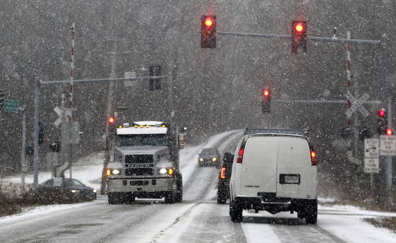 Traffic waits at the traffic light at the intersection of U.S. !2 and Wilmot Road on Wednesday, Feb. 12, 2025, as a winter storm starts to bring heavy snow to the McHenry County area.