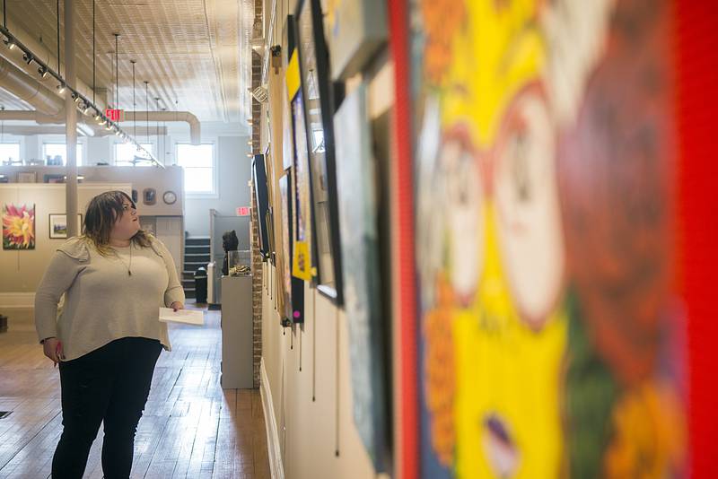 Dixon native Sydni Reubin checks out the entries up for judging Wednesday, March 30, 2022 of the 73rd Phidian Art Show. The show moved from the Loveland House to The Next Picture Show this year after being postponed due to COVID since 2019.