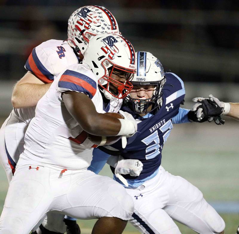 Prospect's George Davis (32) puts a hit on St. Rita's Dj Stewart (17) during the second round of the IHSA Class 7A Playoffs Friday November 4, 2022 in Mount Prospect.