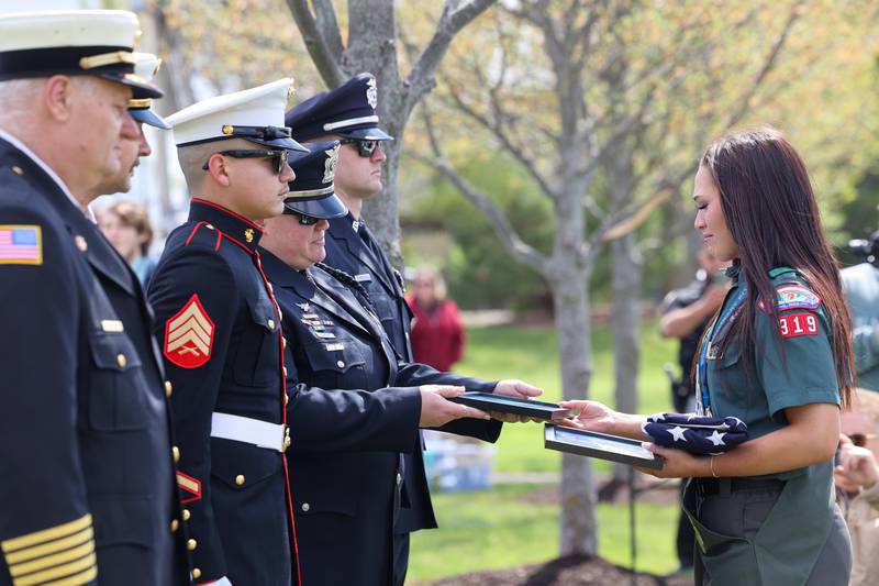 Alexis McCullough, right, is presented with a flag and certificates during the Gold Star Families Memorial Monument dedication ceremony at Marcotte Park in Bourbonnais on Saturday, April 26, 2025. The project was planned and fundraised for by 17-year-old McCullough, of Bourbonnais, for her Eagle Scout project in honor of her father, Col. Mark McCullough.