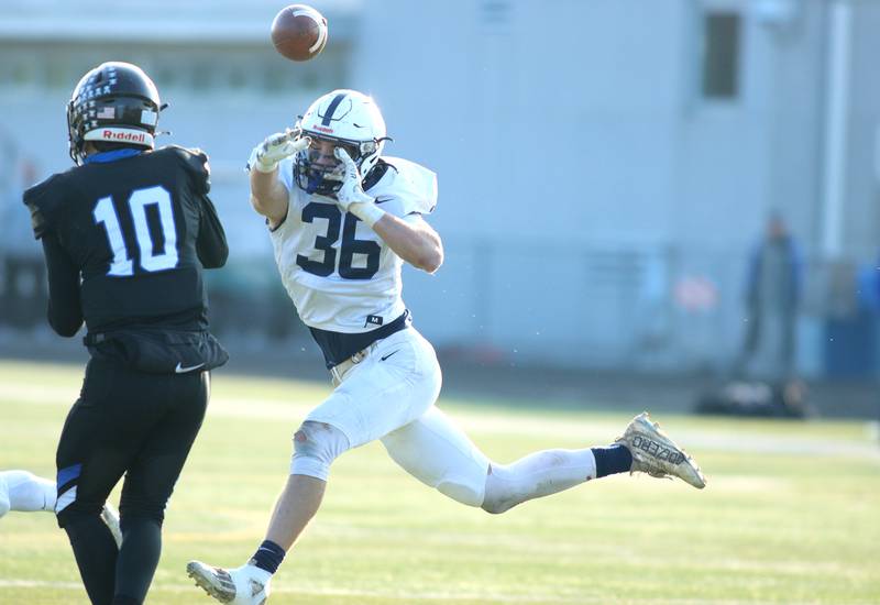 Cary-Grove’s Kyle Jarecki, right, pressures Highland Park’s quarterback David Finfer in second-round IHSA Class 6A playoff action at Wolters Field in Highland Park Saturday.