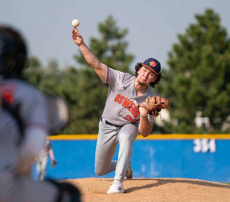 Oswego’s Jordan Logan (22) delivers a pitch against Oswego East during a baseball game at Oswego East High School on Tuesday, May 10, 2022.