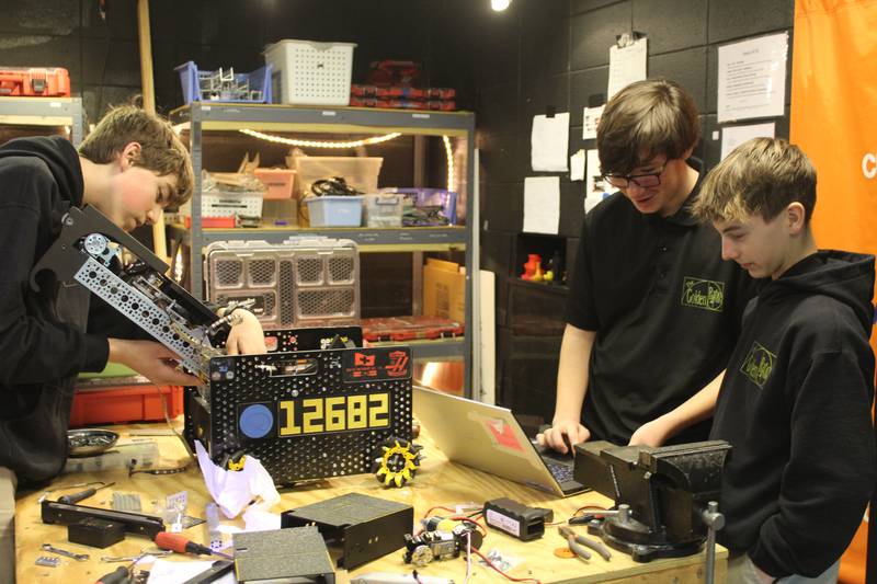 The Golden Ratio teammates Josiah Ryan, Nehemiah Schultz and Ryan Nolan work on building and programming their robot before the big competition.
