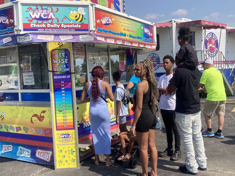 Families buy tickets for carnival rides at the Shorewood Crossroads Festival on Saturday, August 2, 2025.