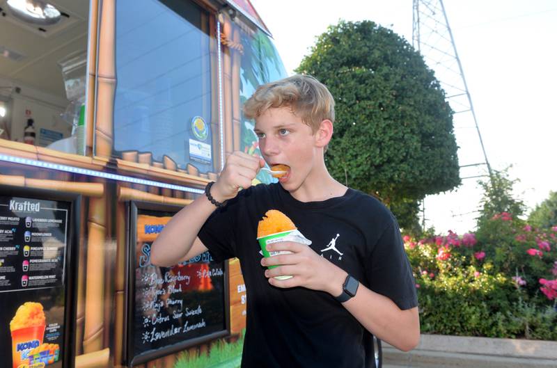 Soren Tobias, 12, of Dixon, takes a scoop of his Kona ice treat at the Dixon City Market on Wednesday. The uptick in summer temperatures is prompting Sauk Valley residents to seek ways to beat the heat. He said he has been coping wth the heat by carrying a bottle of water with him when he's outside.