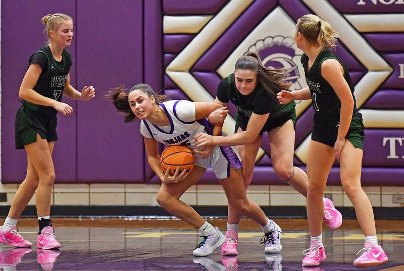 Downers Grove North’s Adysen Fanta tries to escape with the ball as she is fouled by Glenbard West’s Ellie Noble during a game on January 17, 2026 at Downers Grove North High School in Downers Grove .