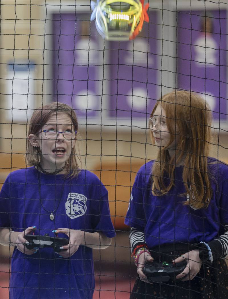 Aislinn Bennett (left) and Genevieve Haag, both 11, fly their drones during a drone soccer scrimmage Wednesday, Jan. 25, 2024.