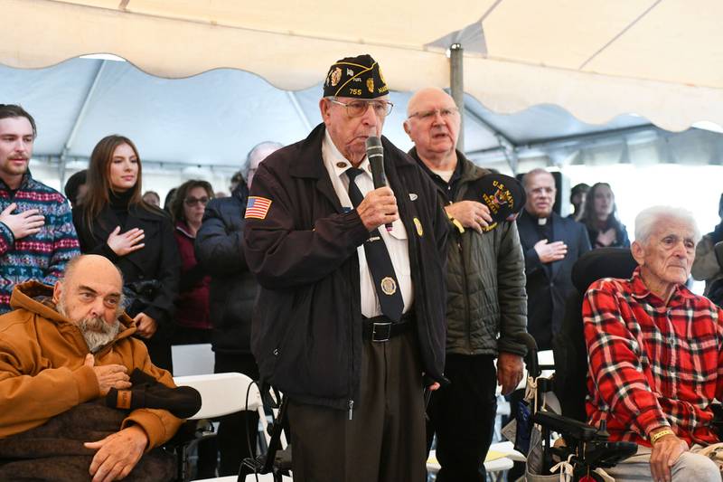 Flanked by fellow veterans to his left and right, John McAdoo, U.S. Navy Korean War veteran, leads the Pledge of Allegiance on Saturday at the Ray Olley Memorial Project’s 2024 Women of War ceremony at A.N. Webber in Kankakee.