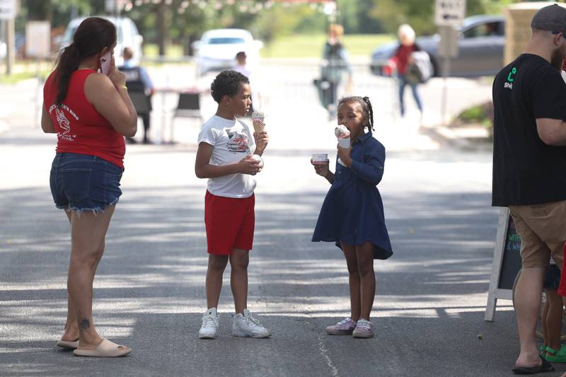 Darrius McCarty, center, and his sister Samarra enjoy their ice cream at the 6th Annual Joliet Blues Festival on Saturday, Aug. 10, 2024 at Bicentennial Park.