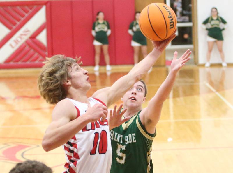 LaMoille's Connor Deering stretches his arm to grab a rebound over St. Bede's Halden Hueneburg on Tuesday, Feb. 11, 2025 at LaMoille High School.