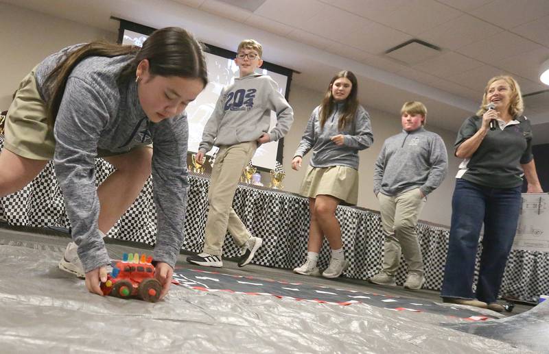 Trinity Catholic Academy students (from left) Mary Simonetta, Preston Vasquez, Hanna Waszowiak and Maks Baker pick up their car after racing it during the 18th annual Editable Car Contest on Wednesday, Feb. 28, 2024 at Illinois Valley Community College in Oglesby.