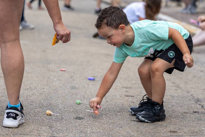 Cohen Martin grabs candy thrown from parade on Sunday, Aug 31, 2025 at the Labor Day parade on Main Street in Streator.