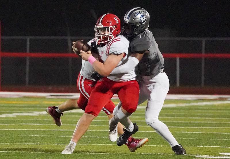 Oswego East's Andrew Wiggins (1) wraps up Yorkville's Michael Dopart (9) for a sack during a football game at Yorkville High School on Friday, Oct. 13, 2023.