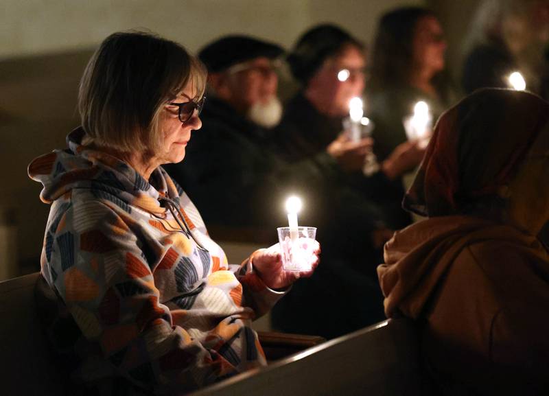 Visitors sit in quiet reflection while holding their candles Monday, Feb. 2, 2026, during the Vigil for Peace at the First Congregational United Church Of Christ in DeKalb. The vigil is being held in remembrance of those lost in recent ICE related shootings and to show solidarity with the people of Minnesota.